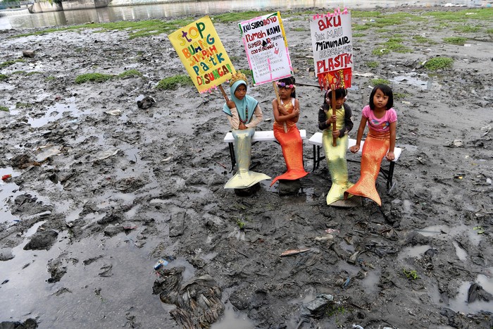 Sejumlah anak dengan kostum putri duyung membentangkan poster saat aksi di Sungai Kalimas, Surabaya, Jawa Timur, Senin (17/2/2020). Mereka mengimbau masyarakat Surabaya agar tidak membuang sampah plastik di sungai. ANTARA FOTO/Zabur Karuru/ama.