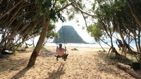 Pemandangan pantai di sini ciamik, lewat panorama pepohonan, pasir pantai putih, dan juga bukit kecil. Punya bibir pantai yang cukup luas, tempat ini juga bisa untuk aktivitas camping. Namun sebelum mendirikan tenda camping, traveler perlu berkoordinasi dengan petugas setempat untuk nanti diarahkan di tempat terbaik dan aman. (Pradikta Kusuma/dtraveler)  