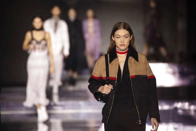 Selain Bella, kakaknya, Gigi juga berlenggang di catwalk Burberry. Ia menebar pesona dalam balutan jumpsuit hita yang dibungkus jaket bomber oversized. (Foto: Vianney Le Caer/Invision/AP)