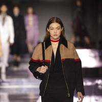 Selain Bella, kakaknya, Gigi juga berlenggang di catwalk Burberry. Ia menebar pesona dalam balutan jumpsuit hita yang dibungkus jaket bomber oversized. (Foto: Vianney Le Caer/Invision/AP)