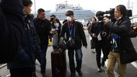 Seorang penumpang kapal pesiar Diamond Princess yang dikarantina di Yokohama, Jepang, tampak diwawancarai oleh sejumlah awak media selepas ia turun dari kapal pesiar tersebut, Rabu (19/2/2020). AP Photo/Jae C. Hong.