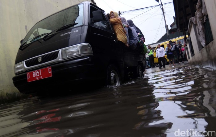 Jalan Terendam Banjir, Siswa TK Diangkut Pick Up Banjir di Gedebage, Kota Bandung, membuat aktivitas warga terganggu. Siswa TK yang akan berangkat ke sekolah terpaksa diangkut dengan mobil pick up.