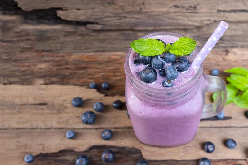 Blueberry smoothies juice beverage healthy the taste yummy In glass drink episode morning on wooden background.