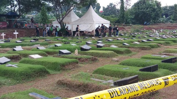 Garis polisi melintang di dekat area makam tempat autopsi dilakukan.