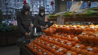 Selain mengenakan masker, sejumlah warga di wilayah Beijing, China, juga mengenakan pakaian pelindung guna mencegah terinfeksi virus corona. Miriam Saleh via AP.