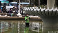 Untuk mengecat fisik air mancur, petugas turun ke dalam air.