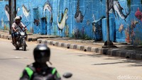 Dinding jalan yang sebelumnya polos itu kini dihiasi dengan mural bertema hewan laut.