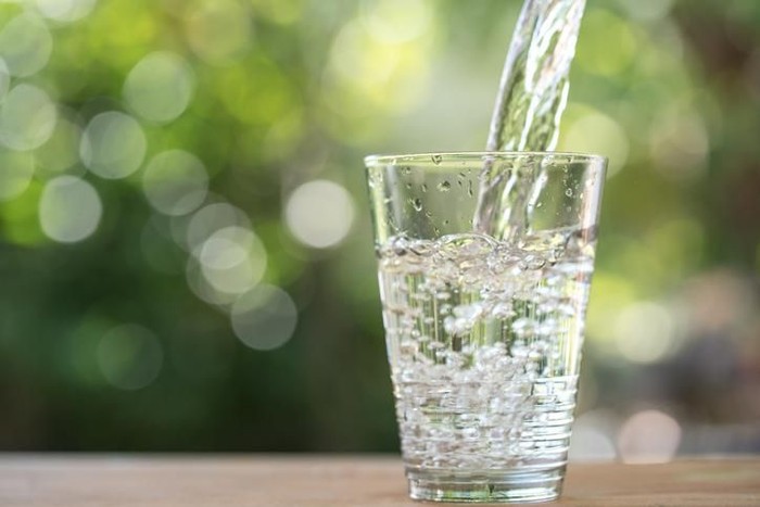 Glass of water on nature background.