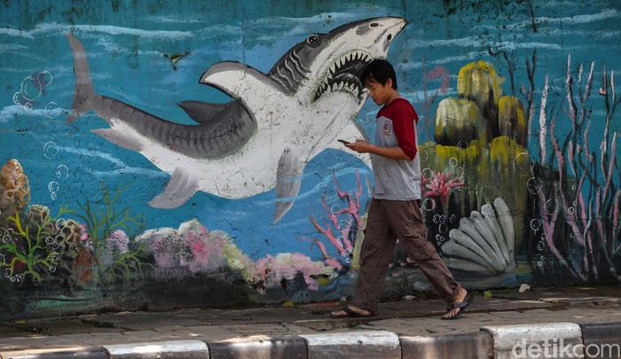 Mural bertema hewan laut menghiasi dinding Jalan Jembatan Tiga Raya di Jakarta. Keberadaan mural itu guna mempercantik kawasan tersebut.