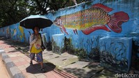 Beragam hewan laut mulai dari ikan hingga gurita menghiasi dinding di Jalan Jembatan Tiga Raya, Jakarta.
