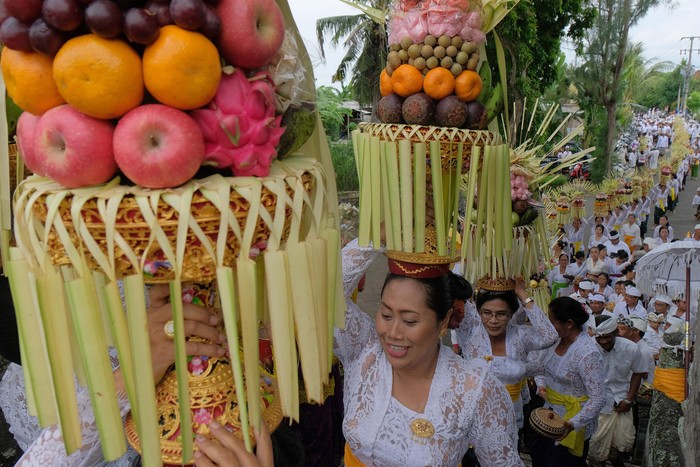 TRADISI MAPEED HARI RAYA GALUNGAN Sejumlah perempuan Bali mengusung Gebogan atau sesajen berisi buah, kue, bunga dan hiasan janur dalam tradisi Mapeed yaitu rangkaian persembahyangan Hari Raya Galungan di Desa Lukluk, Badung, Bali, Rabu (19/2/2020). Tradisi parade sesajen tersebut dilakukan menjelang persembahyangan bersama di Pura Dalem dalam merayakan hari kemenangan