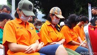 Lucinta Luna (kiri) tampak memakai topi, kacamata dan tertunduk lesu.