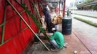 Para pekerja tengah menyiapkan ornamen gigi balang yang akan dipasang.