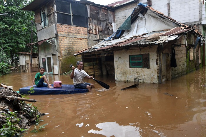Warga menyusuri jalan perkampungan yang tergenang banjir luapan air Sungai Ciliwung di Cawang, Jakarta, Kamis (20/2/2020). Berdasarkan data Badan Penanggulangan Bencana Daerah (BPBD) DKI Jakarta, terdapat 28 RW di 16 kelurahan dan 10 kecamatan se-Jakarta yang mengalami banjir akibat tingginya intensitas hujan di Jakarta dan sekitarnya sejak Rabu (19/2) malam hingga Kamis pagi. ANTARA FOTO/Aditya Pradana Putra/ama.
  *** Local Caption ***