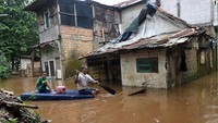 Warga menggunakan perahu buatan saat menyusuri perkampungan yang terendam banjir di kawasan Cawang, Jakarta, Kamis (20/2/2020).