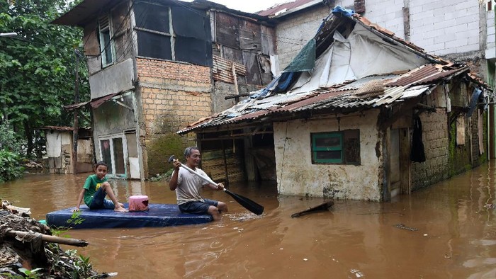Warga menyusuri jalan perkampungan yang tergenang banjir luapan air Sungai Ciliwung di Cawang, Jakarta, Kamis (20/2/2020). Berdasarkan data Badan Penanggulangan Bencana Daerah (BPBD) DKI Jakarta, terdapat 28 RW di 16 kelurahan dan 10 kecamatan se-Jakarta yang mengalami banjir akibat tingginya intensitas hujan di Jakarta dan sekitarnya sejak Rabu (19/2) malam hingga Kamis pagi. ANTARA FOTO/Aditya Pradana Putra/ama.
  *** Local Caption ***