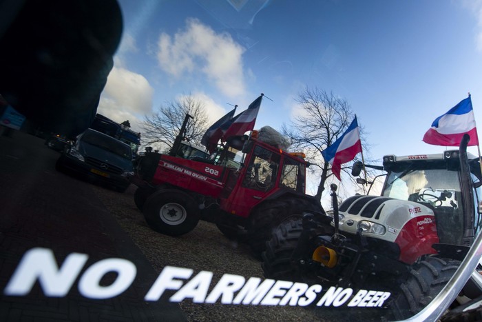 Bawa Traktor, Petani Belanda Kembali Turun ke Jalan Police, front, and army trucks, rear, block the roads leading to parliament during a farmers demonstration in The Hague, Netherlands, Wednesday, Feb. 19, 2020. Dutch farmers, some driving tractors, poured into The Hague on Wednesday to protest government moves to rein in carbon and nitrogen emissions to better fight climate change. (AP Photo/Peter Dejong)