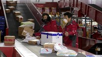 Dua orang petugas tengah sibuk menyortir paket sebelum dikirimkan di sebuah kantor yang berada di kawasan Beijing, China.