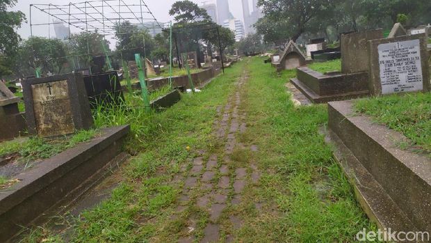 Jalan setapak tengah makam TPU Menteng Pulo yang dilewati pemotor