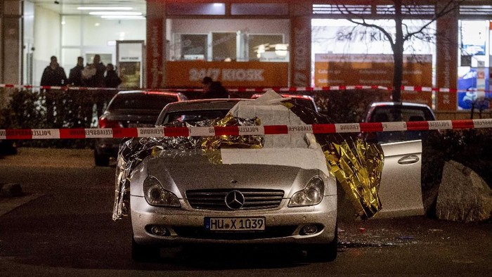 A car with dead bodies stands in front of a bar in Hanau, Germany, Thursday, Feb. 20, 2020. German police say several people were shot to death in the city of Hanau on Wednesday evening. (AP Photo/Michael Probst)