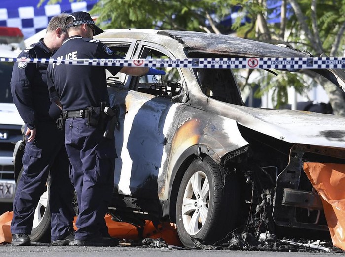 In this Wednesday, Feb. 19, 2020, photo, police attend the scene of a car fire in Brisbane, Australia. Hannah Baxter, 31, and her children Aaliyah, 6, Lainah, 4, and Trey, 3, died after their car was set alight on a street in suburban Brisbane on Wednesday morning. (Dan Peled/AAP Image via AP)