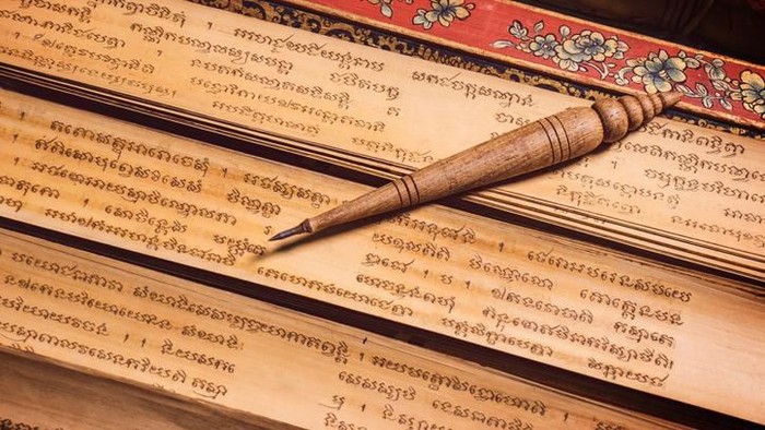 Bangkok, Thailand - November 8, 2018 : pen for writing text on Bai Lan background, Bai Lan or ancient palm leaf manuscripts content about buddhist scriptures, Pali language Khmer