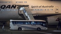 Sebuah bus yang mengangkut sejumlah penumpang kapal pesiar Diamond Princess berhenti di depan salah satu pesawat yang berada di Bandara Haneda, Tokyo, Jepang. Getty Images/Tomohiro Ohsumi.