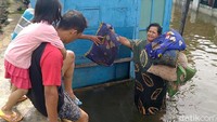 Banjir yang mulai surut membuat warga mulai kembali ke rumah untuk membersihkan rumah mereka.