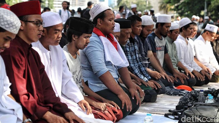 Massa Aksi 212 melaksanakan salat asar berjemaah di Jalan Medan Merdeka Barat, Jakarta, Jumat (21/2/2020). Salat berjemaah dilakukan di sela-sela aksi.