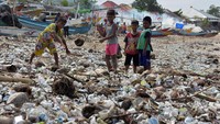 Sejumlah anak bermain di tengah tumpukan sampah yang menumpuk di Pantai Kedonganan, Badung, Bali.
