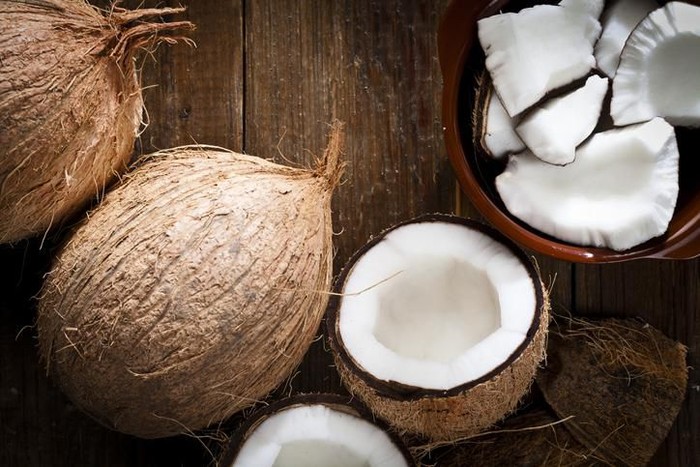 Bowl with organic coconut and fresh coconut shot from above on rustic wood table.  DSRL studio photo taken with Canon EOS 5D Mk II and Canon EF 100mm f/2.8L Macro IS USM