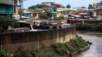 Jalan yang dijadikan lahan parkir tersebut merupakan hasil normalisasi pelebaran sungai Ciliwung di kawasan Kampung Pulo (sisi timur) dan Bukit Duri (sisi barat). 