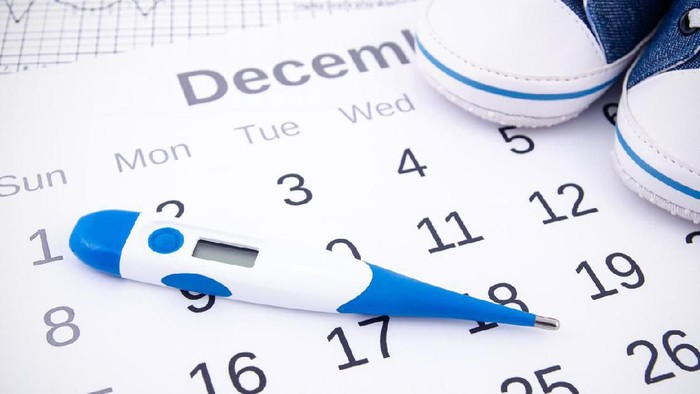 Masa subur Electronic thermometer in fertility concept on calendar
