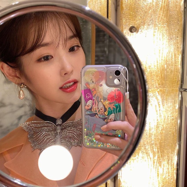 IU pun menyempatkan berpose selfie sebelum datang ke show Gucci. Dia memamerkan ponselnya yang dilengkapi casing cantik bertema bawah laut. Foto: Instagram @dlwlrma