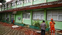 Petugas Pekerja Penanganan Sarana dan Prasarana Umum (PPSU) dari Kelurahan Bambu Apus, Jakarta Timur, membantu membersihkan puing reruntuhan atap bangunan yang ambruk, Jakarta, Jumat (21/2/2020).