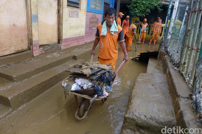 Aksi Bersih-bersih Lumpur Sisa Banjir di Rawajati Banjir di Keluarahan Rawajati, Jakarta Selatan, telah surut. Petugas pun bahu membahu membersihkan lumpur sisa banjir.