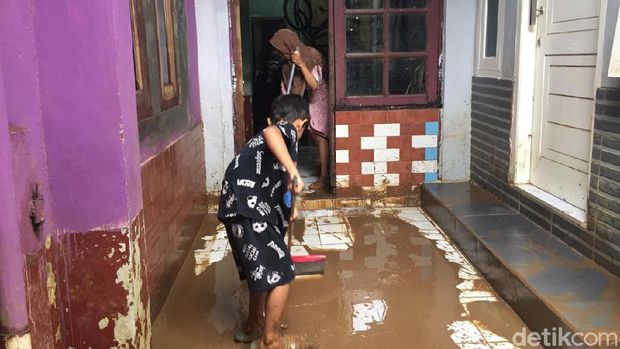 Petugas dan warga membersihkan lumpur sisa banjir di Rawajati, Pancoran, Jakarta Selatan