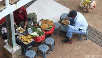 Seorang warga terlihat menikmati sajian makanan yang dijual pedagang.