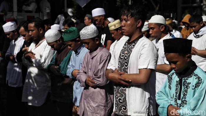 Massa Aksi 212 melaksanakan salat asar berjemaah di Jalan Medan Merdeka Barat, Jakarta, Jumat (21/2/2020). Salat berjemaah dilakukan di sela-sela aksi.