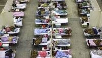 Ranjang-ranjang tempat tidur disusun berjejer untuk para pasien virus corona yang ditangani di rumah sakit darurat. Chinatopix via AP Photo.