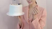 Model video klip Fly to The Sky ini terlihat sangat manis mengenakan blazer pink. Ia membawa kue ulang tahun sederhana namun tetap memikat. Foto: Instagram jihye8024