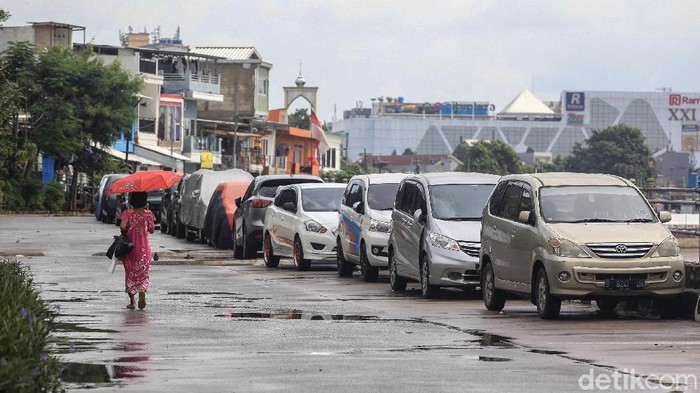 Warga memarkir kendaraan roda 4 di jalan Inspeksi Kali Ciliwung, Jakarta, Jumat (21/2/2020). Jalan tersebut merupakan hasil normalisasi pelebaran sungai Ciliwung di kawasan Kampung Pulo (sisi timur) dan Bukit Duri (sisi barat) beberapa waktu lalu. Namun, arus lalu-lintas yang tidak ramai membuat warga menjadikan satu lajur jalan sebagai lahan parkir tetap layaknya garasi mobil di rumah. Beberapa menggunakan penutup badan mobil untuk menghindari sinar matahari dan hujan. Rumah di sisi jalan hanya gang yang tidak terdapat akses untuk mobil.