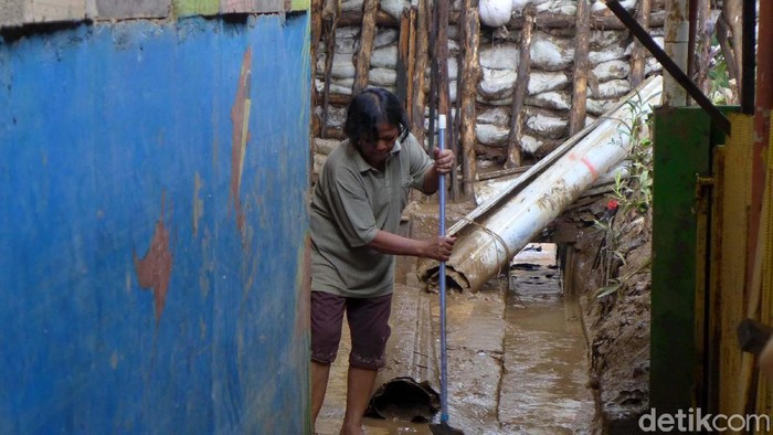 Banjir di Keluarahan Rawajati, Jakarta Selatan, telah surut. Petugas pun bahu membahu membersihkan lumpur sisa banjir.