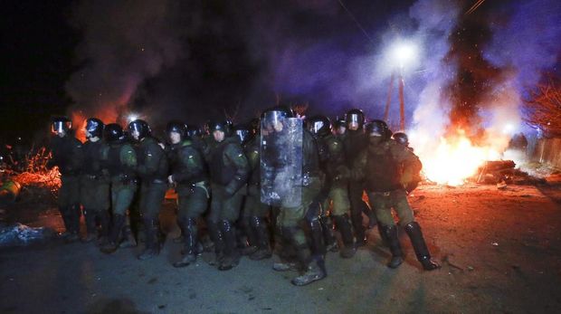 Bentrokan terjadi saat polisi hendak membuka jalan yang diblokir oleh demonstran yang menolak warga Ukraina yang dievakuasi dari Wuhan karena virus corona