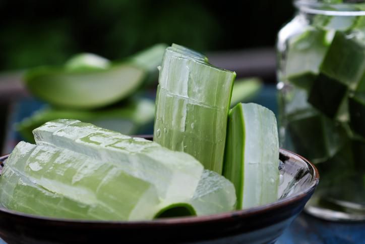 Healthy Aloe vera juice in a mason jar glass. Top view scene on a wooden paddle board.