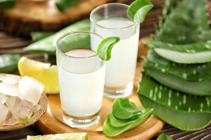 Healthy Aloe vera juice in a mason jar glass. Top view scene on a wooden paddle board.