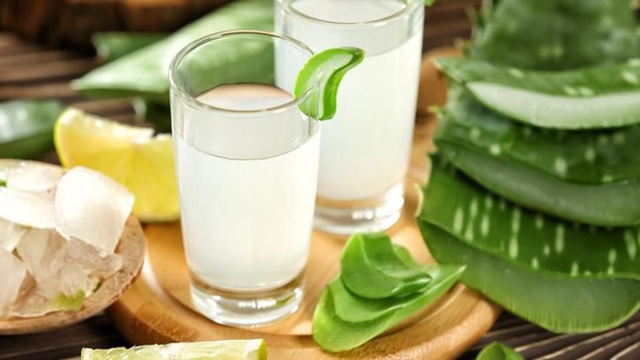 jus lidah buaya Healthy Aloe vera juice in a mason jar glass. Top view scene on a wooden paddle board.
