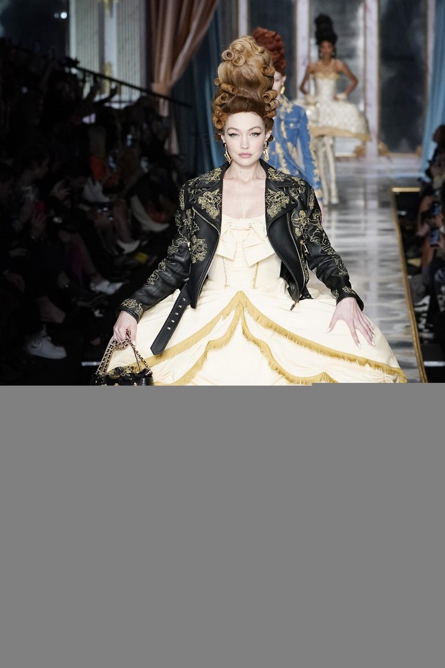 Kakak Bella, Gigi Hadid, memakai dress bersiluet sama, tapi dipadukan dengan jaket kulit yang edgy. (Foto: Pietro S. DAprano/Getty Images)