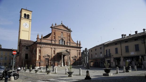 Two reporters stand in front of the San Biagio Church in Codogno, near Lodi, Northern Italy, Saturday, Feb. 22, 2020. A dozen northern Italian towns were on effective lockdown Saturday after the new virus linked to China claimed two fatalities in Italy and sickened an increasing number of people who had no direct links to the origin of the virus. The secondary contagions prompted local authorities in towns in Lombardy and Veneto to order schools, businesses and restaurants closed, and to cancel sporting events and Masses. (AP Photo/Luca Bruno)