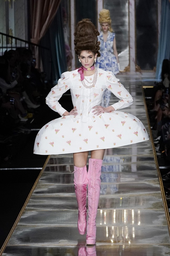 Penampilan lain dari Kaia Gerber. Bedanya, gaun putih dan boots pink menemani penampilannya. (Foto: Pietro S. DAprano/Getty Images)